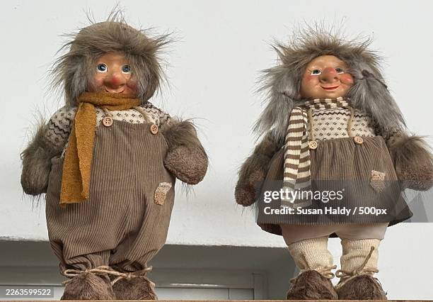 two whimsical troll dolls with furry hair and traditional outfits stand against a white background - charming stock pictures, royalty-free photos & images