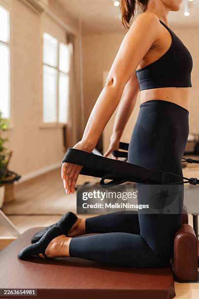 close up of woman using reformer straps during pilates - flexibility stock pictures, royalty-free photos & images