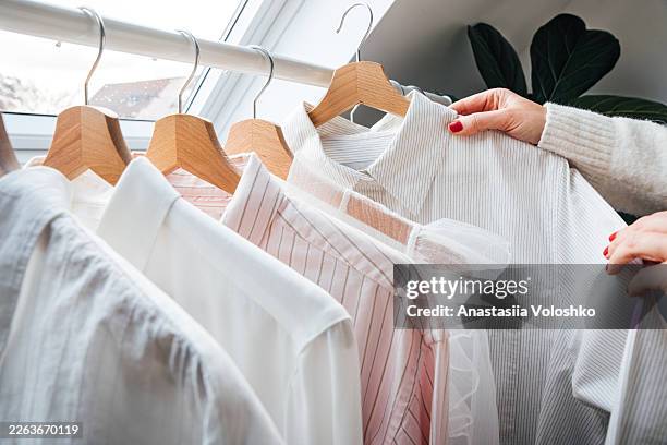 woman choosing outfit from capsule wardrobe at home - fashion stylist stock pictures, royalty-free photos & images