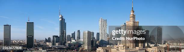 Very wide stitched panorama shows the full winter morning skyline visible from a high floor of a central Warsaw hotel, stretching across central...