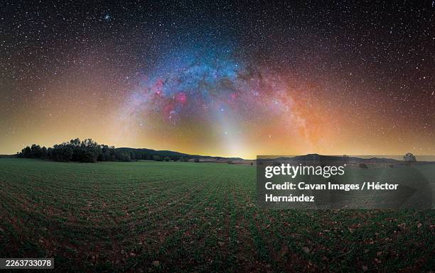 milky way with constellations and zodiacal light over green meadow - zodiacal light stock pictures, royalty-free photos & images