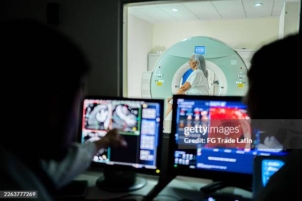 ältere patientin, die auf eine magnetresonanzuntersuchung im krankenhaus wartet - wissenschaftliche bildtechnik stock-fotos und bilder