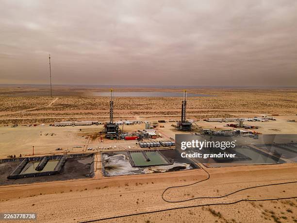 vue aérienne du site de forage pétrolier avec opérations de fracturation hydraulique dans un paysage désertique - argile schisteuse photos et images de collection