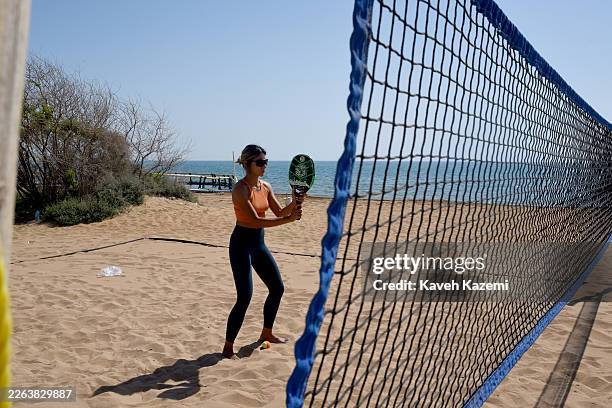 Young woman in sporting attire and not wearing the veil plays beach tennis by the beach on February 20, 2026 in Qeshm Island, Iran.