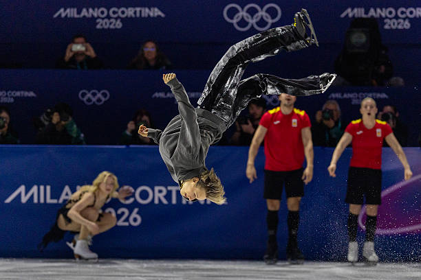 February 21: Ilia Malinin of the United States performs a back flip watched by Amber Glenn of the United States during the Olympic Figure Skating...