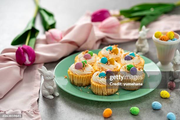 mini cheesecake bird's nest with whipped cream and mini candy eggs for easter dessert. - easter cake stock pictures, royalty-free photos & images