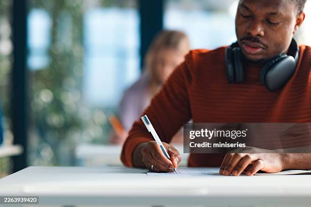 high school student studying together in library with headphones preparing for university exams - ballpoint pen stock pictures, royalty-free photos & images