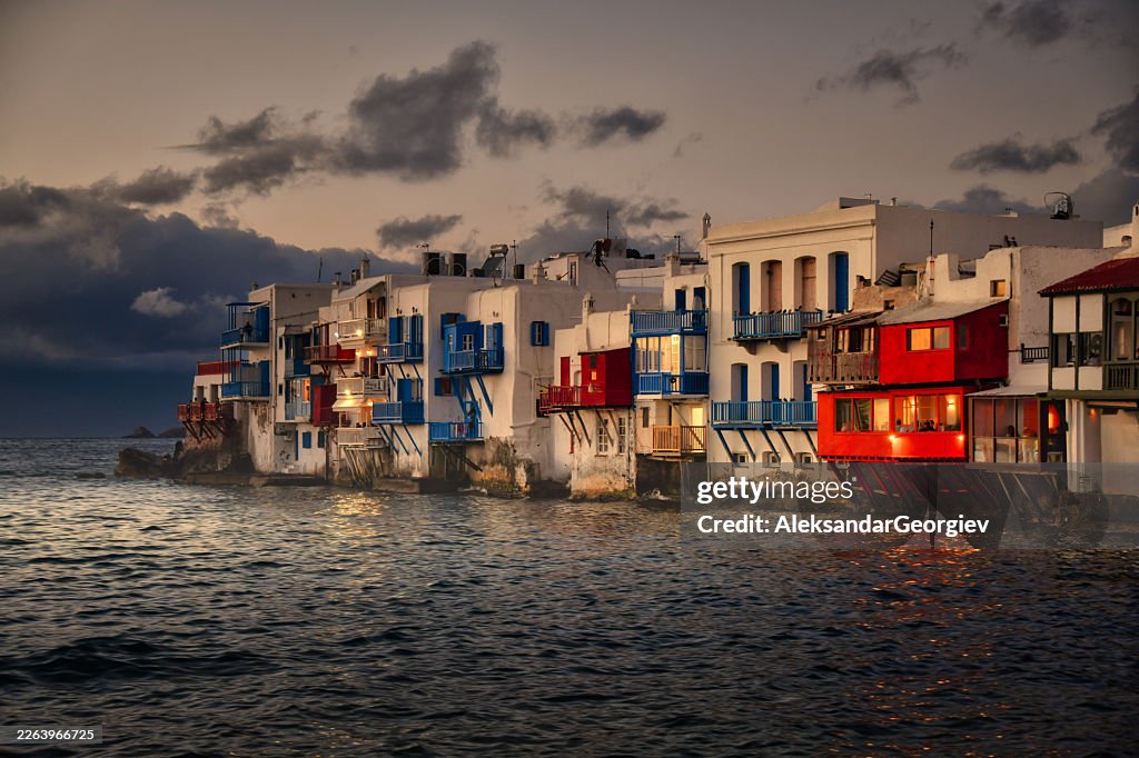 Little Venice Mykonos bei Einbruch der Dämmerung: Bunte Häuser am Wasser mit Balkonen mit Blick auf die Ägäis
