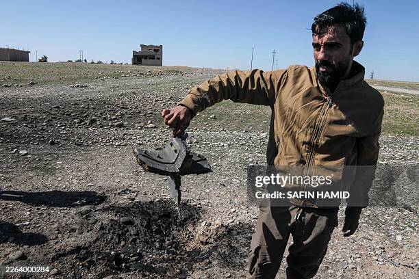 Man shows the remains of a drone that was reportedly aimed at Erbil International Airport and crashed outside Erbil, the capital of the autonomous...