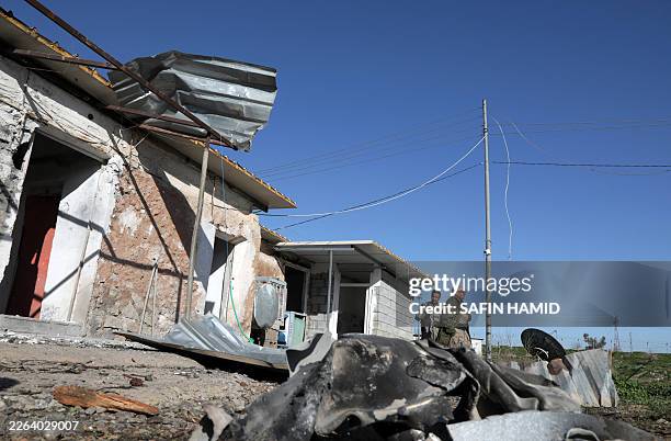 Iranian Kurdish Peshmerga member of the Kurdistan Democratic Party of Iran inspect damage sustained at the Azadi camp of the Kurdistan Democratic...