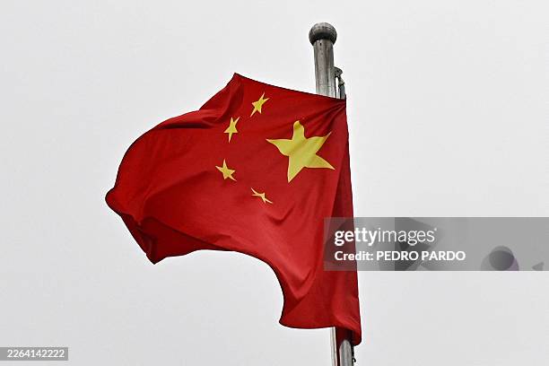 Chinese flag flutters in the wind in a street surrounding the Great Hall of the People where the opening of the Chinese People's Political...