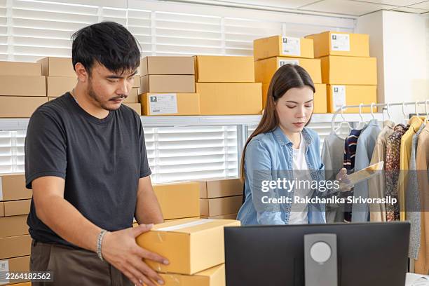 small business owner clothing ecommerce warehouse workflow, discussing barcode scanner results and tablet order review to confirm shipments, prevent packing errors, and manage dispatch logistics. - store directory stock pictures, royalty-free photos & images