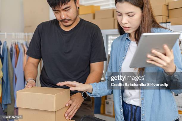 young couple, small business owner work clothing ecommerce warehouse workflow, carrying boxes packing checking tablet records for order processing, tracking customers, and shipment dispatch planning. - store directory stock pictures, royalty-free photos & images