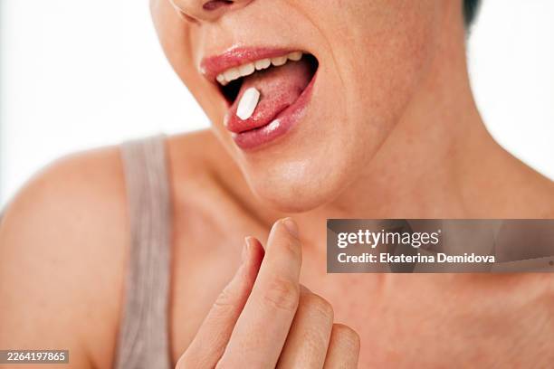 woman taking pill for health and sick care - tongue stock pictures, royalty-free photos & images