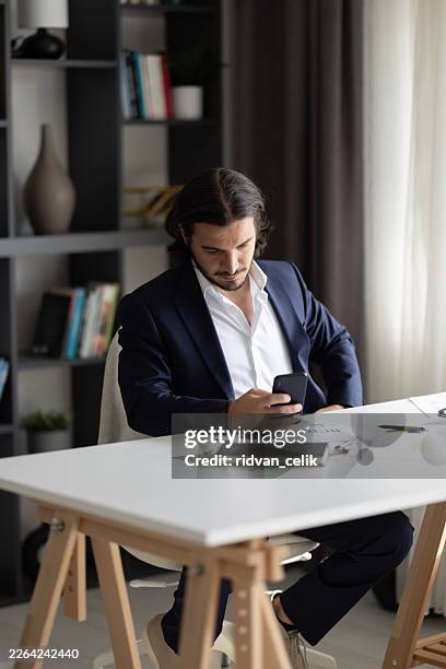professional businessman using smartphone at office desk, checking messages and managing daily tasks - scrolling stock pictures, royalty-free photos & images
