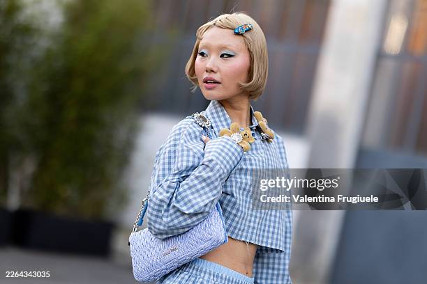 Lin Lin wears blue eyeshadow, a light blue leather bag, blue hair accessories and a cropped long sleeved checked light blue and white shirt with...