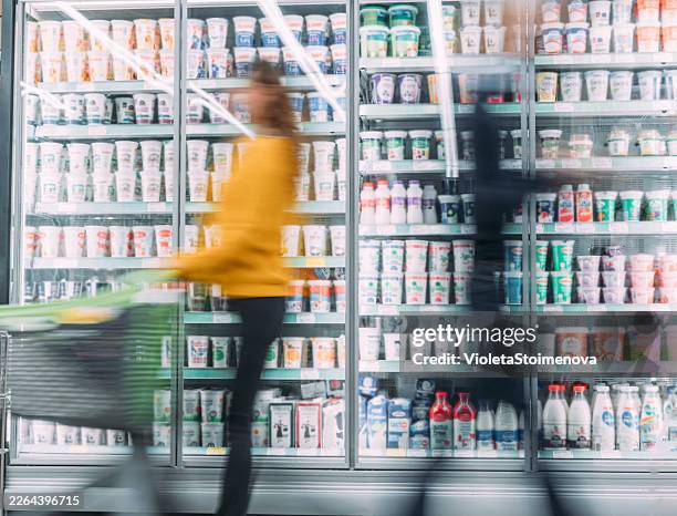 busy customers pushing shopping cart at the supermarket. - aisle stock pictures, royalty-free photos & images