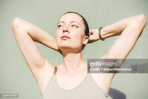 close-up portrait of a smiling woman with glowing skin under warm sunlight. - armpit stock pictures, royalty-free photos & images