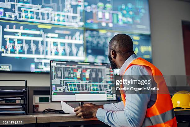 engineer monitoring industrial control system in power plant - kontrollrum bildbanksfoton och bilder