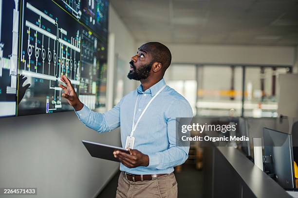 african american engineer monitoring industrial control systems on screen - kontrollrum bildbanksfoton och bilder