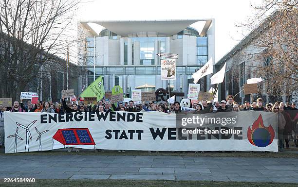 Climate activists from Fridays for Future and other groups hold a banner that reads: "Energy Transition Instead Of The End Of The World" as they...