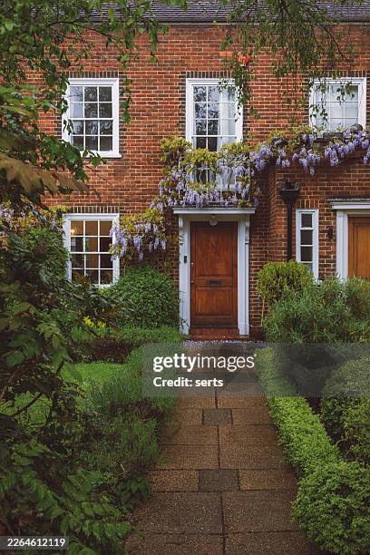 charming london brick townhouse entrance with blooming wisteria and lush garden path in spring, england, uk - brick house stock pictures, royalty-free photos & images