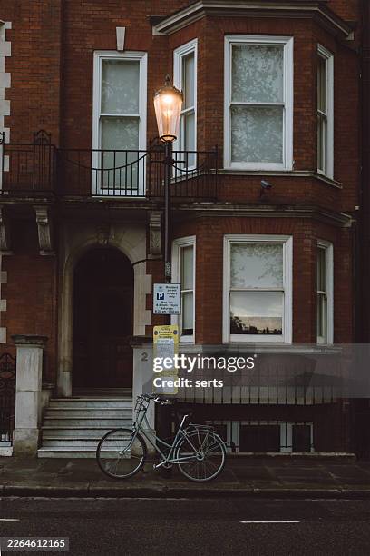 rainy evening street scene with victorian red brick townhouses and glowing street lamp in london, england, uk - holborn stock pictures, royalty-free photos & images