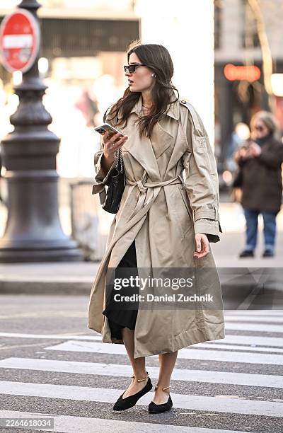 Guest is seen wearing a tan belted trenchcoat, black shoes, black bag and black sunglasses during Day Two of Paris Fashion Week - Womenswear...