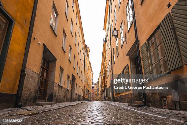 low angle view of cobblestone street in gamla stan, stockholm, sweden - kassei stockfoto's en -beelden