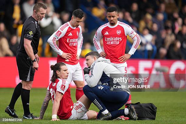 Arsenal's Italian defender Riccardo Calafiori is treated by medical staff after picking up an injury during the English FA Cup fifth round football...