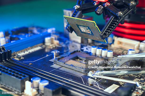 robotic arm interacting with a glowing cpu chip, concept for artificial intelligence and automation. - carte mère photos et images de collection