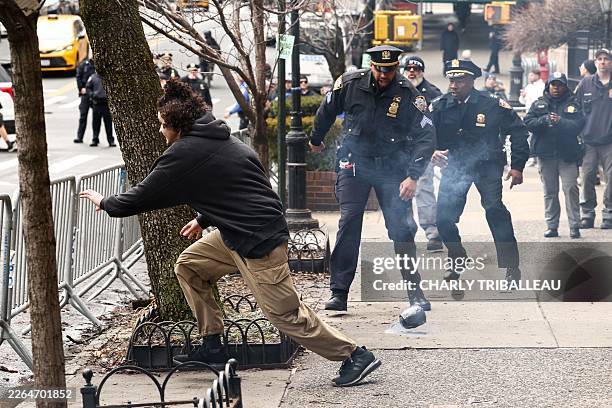 Left-wing activist flees after throwing a homemade explosive device towards police during a protest organized by far-right influencer Jake Lang...