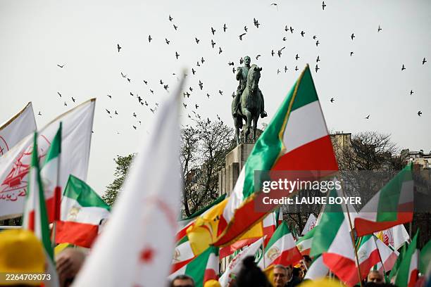 Demonstrators wave Iranian flags during a rally calling for a pluralist and secular republic in Iran organized by several Franco Iranian associations...