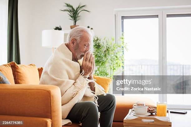senior patient managing flu symptoms at home - cold virus stock pictures, royalty-free photos & images