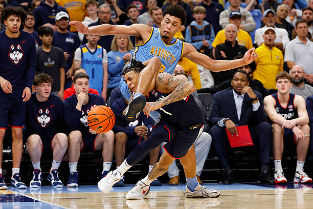 UConn Huskies guard Solo Ball is fouled by Marquette Golden Eagles forward Caedin Hamilton during a game between the Marquette Golden Eagles and the...