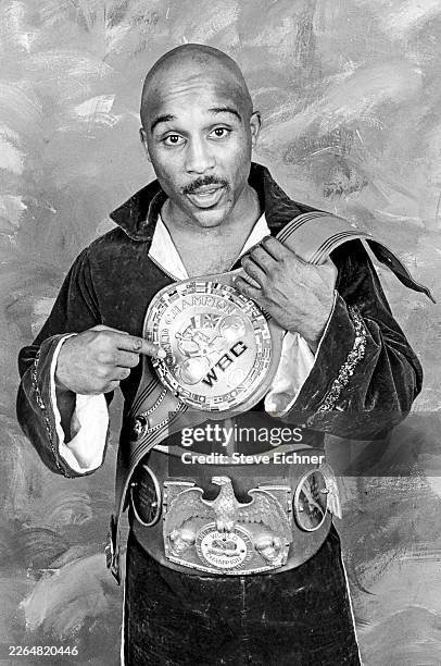 Portrait of American professional boxer Buddy McGirt , wearing both his International Boxing Federation & World Boxing Council title belts, as he...