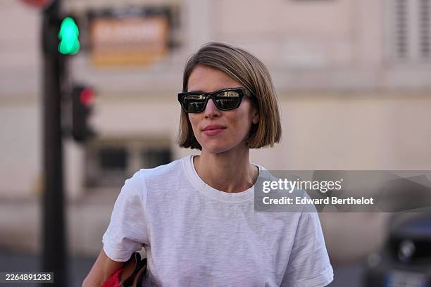 Monica Ainley de La Villardiere wears light brown bob haircut, black sunglasses, a white cotton crew neck t-shirt, outside Dries Van Noten, during...