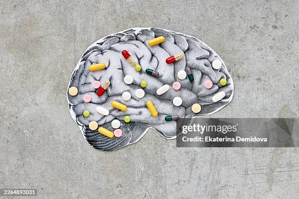 brain image covered with various medication pills - brain fog stock pictures, royalty-free photos & images