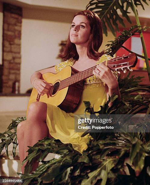 French born American singer and actress Claudine Longet posed playing an acoustic guitar in the United States circa 1966.
