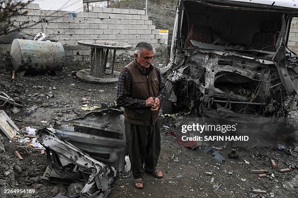 Taha Karimi a member of the Democratic Party of Iranian Kurdistan , stands near his home after it and his truck were damaged in a drone attack...