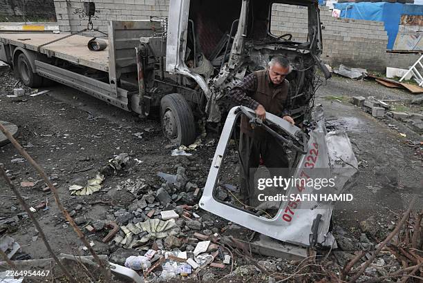 Taha Karimi a member of the Democratic Party of Iranian Kurdistan , stands near his home after it and his truck were damaged in a drone attack...