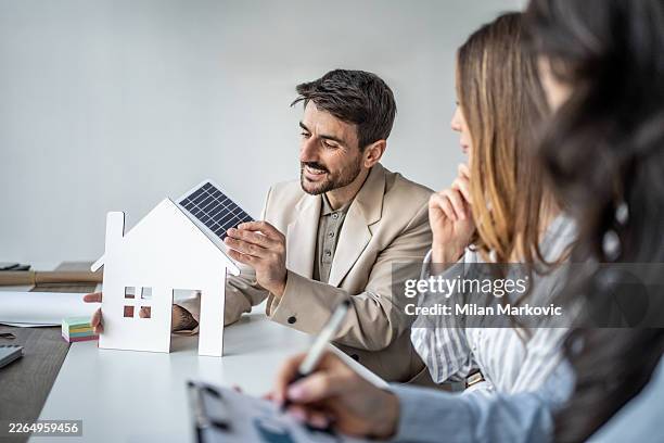 architect discussing solar panel efficiency for sustainable home design - property developer stock pictures, royalty-free photos & images