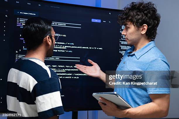 professional programmers working together in front of a screen, sharing ideas and reviewing software tasks. - programming stock pictures, royalty-free photos & images