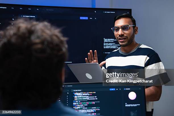 team leader presenting ai code to a team member, discussing project progress in a modern tech office. - data scientist stock pictures, royalty-free photos & images
