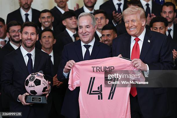President Donald Trump receives gifts from Inter Miami CF CEO and Managing Owner Jorge Mas as Lionel Messi of Inter Miami looks on during an event...