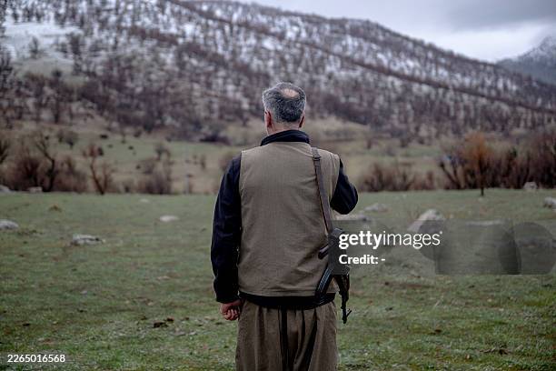 Kurdish fighter from the Iranian Kurdish armed faction Kurdistan Free Life Party stands with his rifle at a site near the Iraqi border with Iran in...