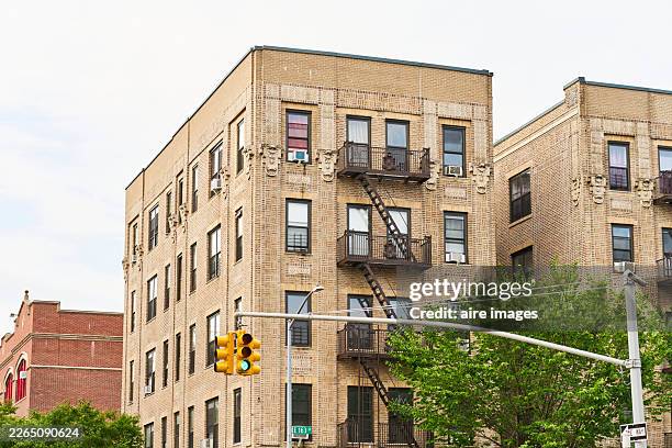 bronx apartment building with fire escape and traffic light - bronx - fotografias e filmes do acervo