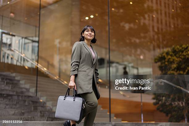 businesswoman walking up stairs in the city - briefcase stock pictures, royalty-free photos & images