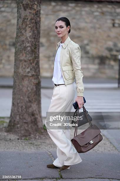 Vittoria Ceretti is seen wearing a cream leather bomber jacket, white crewneck t-shirt, white wide-leg trousers, dark brown belt, dark brown suede...
