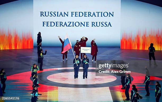 Volunteer Flagbearers of Team Russia walk through the stadium with athletes of Team Russia during the Milano Cortina 2026 Winter Paralympic Games...